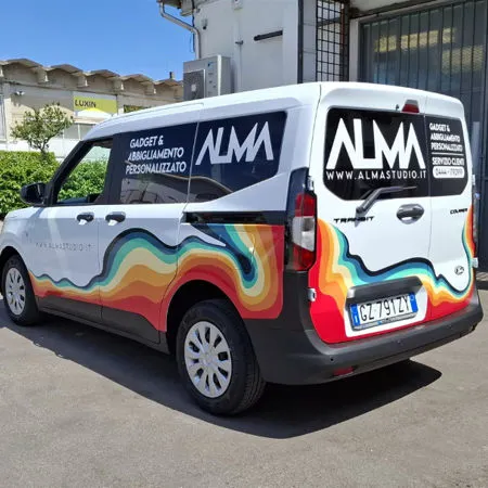 Furgone bianco Alma decorato con una grafica ondulata multicolore sulla fiancata e sul portellone posteriore