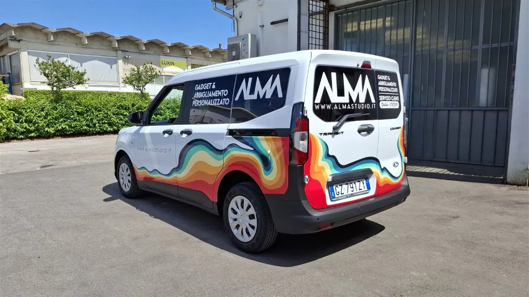Furgone bianco Alma decorato con una grafica ondulata multicolore sulla fiancata e sul portellone posteriore
