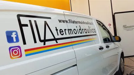 Furgone bianco Fila Termoidraulica con logo colorato e icone social applicati sulla fiancata