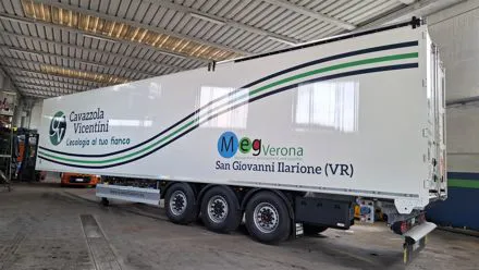 Semirimorchio Cavazzola Vicentini decorato con fasce ondulate verdi e blu e logo aziendale