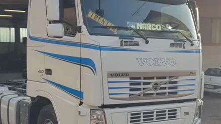 Trattore stradale Volvo bianco con fasce blu decorative sulla cabina e sul paraurti
