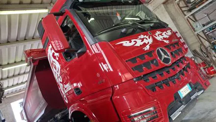 Camion Mercedes rosso con decorazione bianca in stile tribale applicata sulla cabina