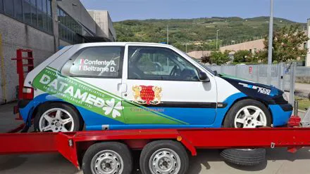 Auto da rally su carrello con grafica verde e blu Datamed applicata sulla carrozzeria