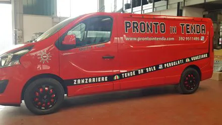 Furgone rosso Pronto in Tenda con scritte bianche e nere applicate sulla fiancata