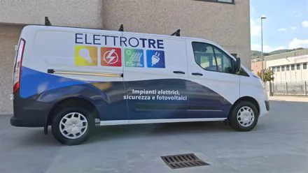 Furgone bianco Elettrotre con grafica blu e la scritta impianti elettrici, sicurezza e fotovoltaici