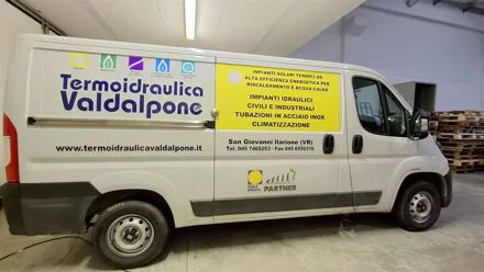 Furgone bianco Termoidraulica Valdalpone con pellicole adesive gialle e blu sulla fiancata