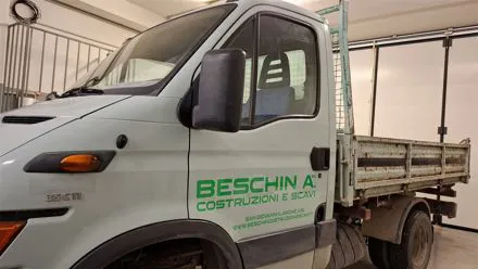 Camion ribaltabile bianco con scritte verdi Beschin Costruzioni e Scavi sulla portiera