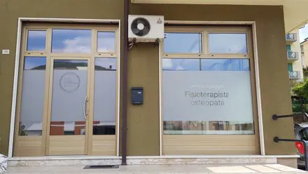 Ingresso di uno studio di fisioterapia e osteopatia con pellicola satinata e scritte sui vetri