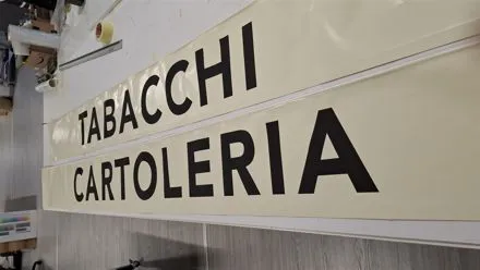Insegna con lettere nere Tabacchi Cartoleria su fondo chiaro