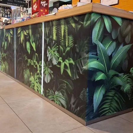 Banco bar lungo rivestito con pellicola adesiva stampata a foglie verdi