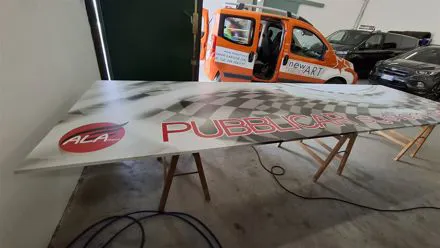 Pannello rigido stampato con logo rosso in lavorazione sul banco del laboratorio