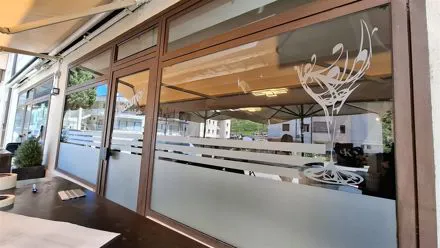 Vetrata di un bar con decoro a calice e fasce in pellicola sabbiata