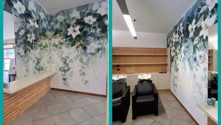 Parete di un salone di parrucchiere decorata con una stampa di grandi fiori bianchi su fondo verde acqua