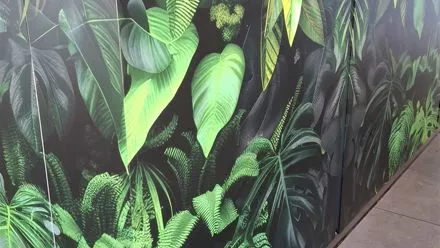 Dettaglio del piano e del fronte di un banco rivestiti con pellicola stampata a foglie tropicali