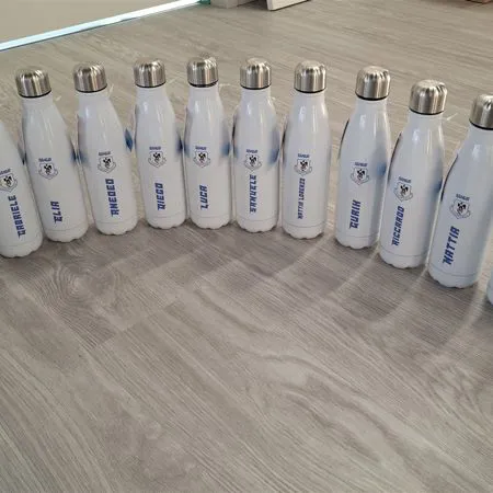 Borracce termiche bianche personalizzate con logo blu disposte in fila