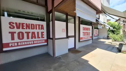 Vetrine di un negozio con grandi cartelli adesivi rossi Svendita totale per rinnovo negozio